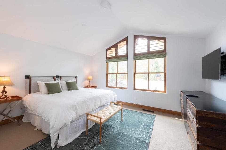 409 S Main St 4C — Primary Ensuite Suite with Custom Walk-In Closets. Ketchum Luxury Townhome. Designed for ultimate rest and relaxation, this spacious primary bedroom features soaring high ceilings, custom walk-in closets, central air conditioning, and peaceful alpine atmosphere just 0.7 miles from River Run Lodge.